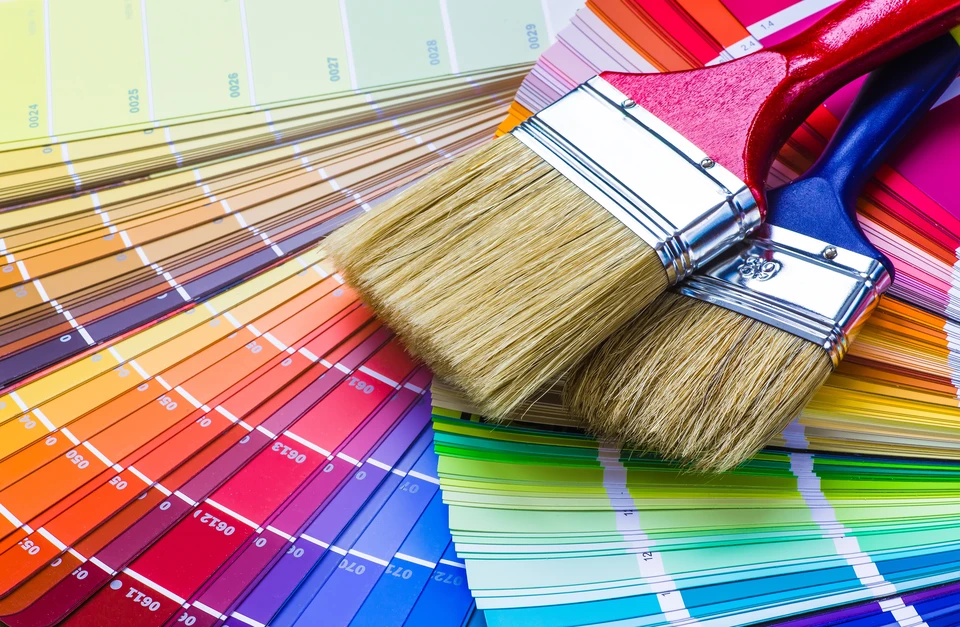 Scène d'atelier intérieur avec pinceaux professionnels disposés sur nuanciers colorés étalés en éventail